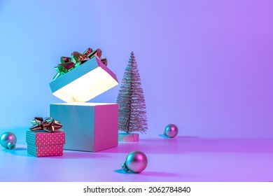 Neon xmas winter background  Open Christmas gift box and shine lights  minimal tree  Holiday decoration bauble ball neon abstract gradient backdrop  Happy new year copy space