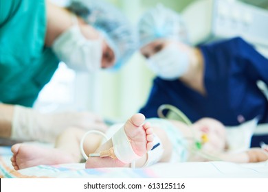 Neonatal Resuscitation. Doctor's team doing intensive therapy to newborn baby