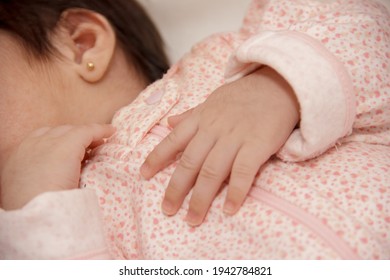neonate close up of ear of Healthy Baby with hands on her chest - Shutterstock ID 1942784821