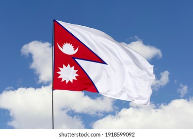 Nepal flag isolated on the blue sky with clipping path. close up waving flag of Nepal. flag symbols of Nepal.