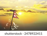 Nepal flag waving with flying doves against sunset or sunrise. Nepal flag for Republic Day and Independence Day.