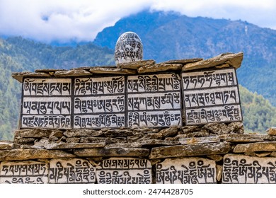 Nepal sacred stones mani with mantra written and carved on the surface. Prayer stones shire on the mountain trekking path on Everest Base Camp trek. Nepali buddhist mantra Om Mani Padme Hum on rock - Powered by Shutterstock