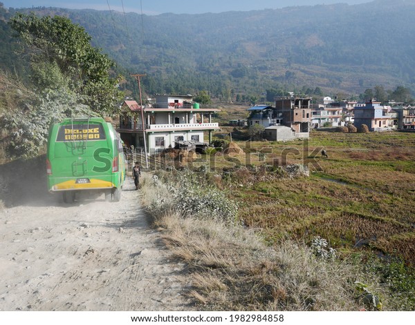 Nepalese driver worker driving retro vintage buses\
for send nepali people and foreign travelers from Kathmandu to\
Pokhara hill village city at Annapurna Valley on December 7, 2017\
in Pokhara, Nepal