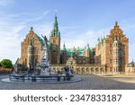 Neptune Fountain in a front of Frederiksborg castle courtyard facade in Hillerod, Denmark, blue sky background