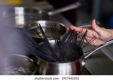 Nera Pasta Is Manually Dipped In A Pot Of Boiling Water In The Kitchen