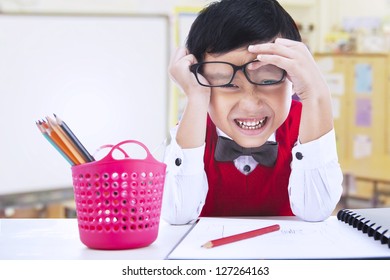 Nerd boy with funny expression in classroom