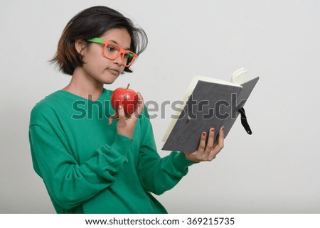 Nerd girl reading book and holding apple