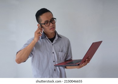 Nerd Guy Talking On Phone While Holding Laptop