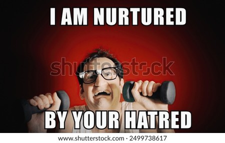 A nerd lifting tiny weights, showing strength and anger but crumbling under the strain. Caption: I am nurtured by your hatred. Reaction meme from online pop culture.
