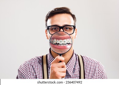 Nerdy Man Is Holding Loupe And Showing His Teeth With Braces.I Have Braces And I Am Still Handsome!