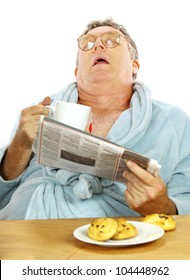 Nerdy Middle Aged Man Falls Asleep At The Breakfast Table With A Cup Of Tea And Muffins.