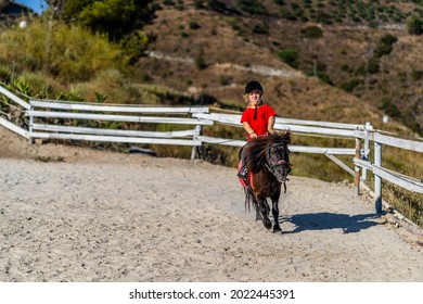 Nerja, Spain - July 14, 2021: Dwarf Girl Anika Brilliantly Riding Pony Horse