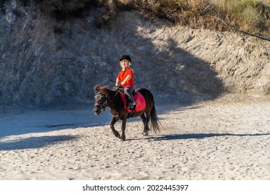 Nerja, Spain - July 14, 2021: Dwarf Girl Anika Brilliantly Riding Pony Horse