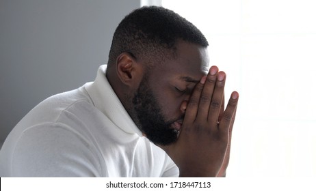 Nervous african american man going through difficult period in life, praying
