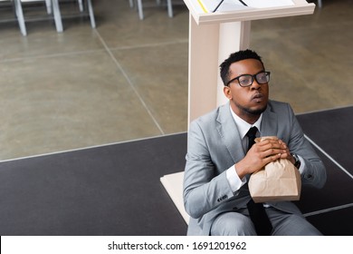 nervous african american speaker holding paper bag and having panic attack before business conference