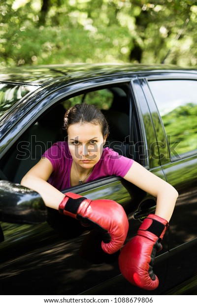 Nervous and bad tempered female driver,wearing\
box gloves white sitting in the\
car.