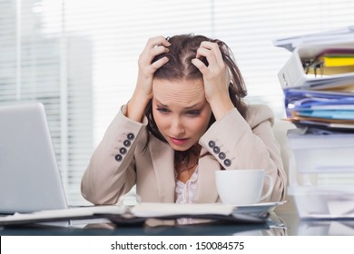 Nervous businesswoman pulling her hair out in her bright office