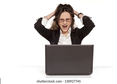 nervous girl on a laptop pulls her hair and screaming on white background