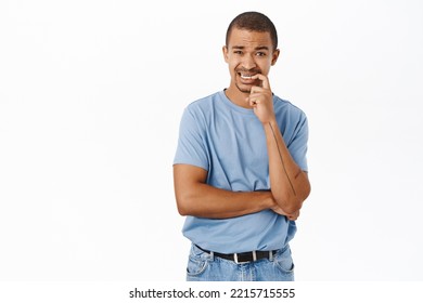 Nervous Guy Biting His Finger And Looking Worried, Having Doubts, Standing Over White Background