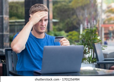 Nervous Horrified Confused Young Man, Stressed Worried Guy Having Problem With Paying, Buying Online, Payments With Credit Blocked Bank Card, Looking At Screen, Monitor Of Laptop. Internet Fraud