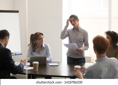 Nervous Indian Female Worker Presenter Speaker Feels Embarrassed And Shy Stands In Front Of Multi-ethnic Colleagues Clients At Conference Business Meeting, Timid Stressed Not Prepared Employee Concept