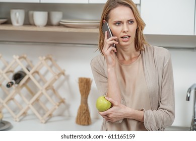 Nervous Lady Talking On Phone In Cook Room