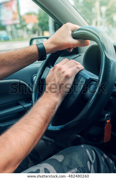 Nervous\
male driver pushing car horn in traffic rush hour, close up with\
selective focus on hand on the steering\
wheel