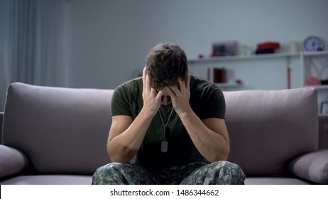 Nervous male military suffering depression, sitting alone at home, PTSD concept