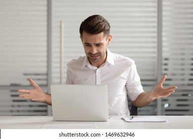 Nervous Male Worker Sit At Office Desk Feel Confused Having Operational Software Problems At Laptop, Frustrated Man Employee Panic Experience Virus Attack Or Computer Breakdown And Data Loss