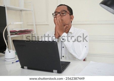 Nervous man thinking over problem trying to focus at work, young businessman sitting at workplace with laptop holding hands in concentration gesture collecting thoughts or making important decision