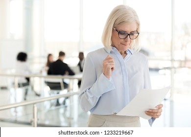 Nervous middle aged old businesswoman feeling scared stressed afraid waiting for job interview, worried mature senior applicant or speaker reading papers preparing for public speaking fear concept