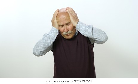 Nervous Old Man Is Very Scared. Studio Portrait Of Old Man Isolated On White Background. The Old Man Feels Anxious And Fearful Tension, Covers His Face With His Hands.