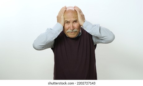 Nervous Old Man Is Very Scared. Studio Portrait Of Old Man Isolated On White Background. The Old Man Feels Anxious And Fearful Tension, Covers His Face With His Hands.