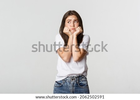 Nervous sad brunette girl leaning on hands and looking left miserable
