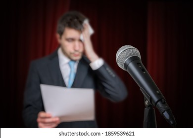 Nervous Speaker Is Afraid Of Public Speech And Is Sweating. Microphone In Front.