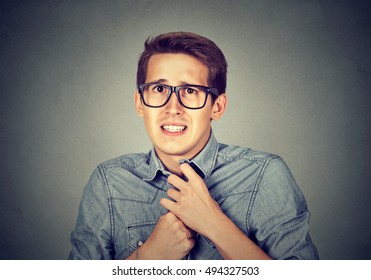 Nervous Stressed Young Man Student Feels Awkward Looking At Camera Anxiously Craving Something Isolated Gray Wall Background. Human Emotion Face Expression Feeling Body Language