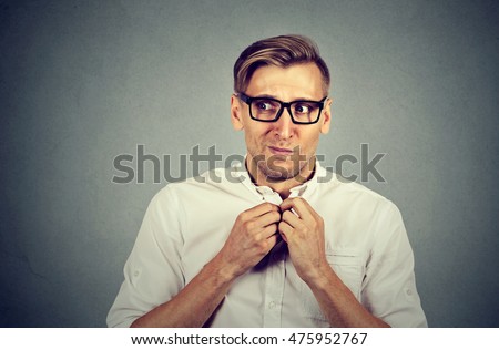 Nervous stressed young man student feels awkward looking away sideway anxiously craving something isolated gray wall background. Human emotion face expression feeling body language