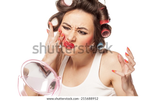 カーラーを持つ神経質な女性は 手で化粧を落とす の写真素材 今すぐ編集