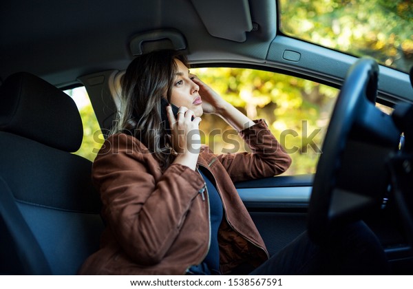 Nervous woman talking\
on the phone in a car