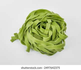 A nest of fresh green spinach fettuccine pasta, ideal for healthy cooking and celebrating Italian cuisine - Powered by Shutterstock