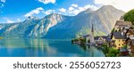 Nestled between majestic mountains, the picturesque village of Hallstatt awakens under the golden rays of sunrise, casting vibrant reflections on the serene lake in Austria