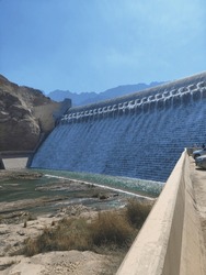 Nestled In Nature's Embrace, The Beautiful Dam Glistens Under The Sunlight, Its Graceful Architecture Blending Seamlessly With The Landscape. Water Cascades Softly Over Its Edge, Creating A Serene Atm