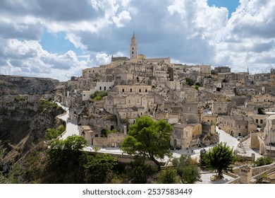 Nestled on a rocky hillside, Matera showcases its historic Sassi district with ancient stone buildings and winding streets, bathed in golden sunlight. Puglia Italy - Powered by Shutterstock