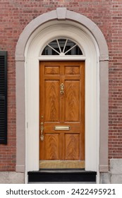 Nestled within a backdrop of rustic red brick, a brown front door exudes warmth and traditional charm, creating a harmonious blend of classic elegance and architectural character.