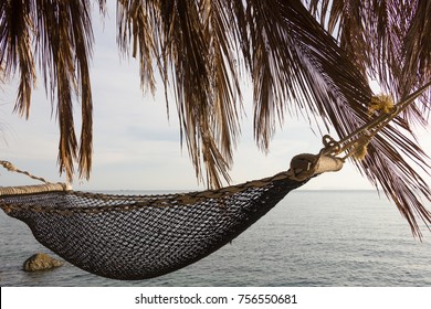 Net hammock under palm tree branches on beach bar shack by the sea in the island of Koh Pha Ngan, Thailand. Summer travel vacation, holidays destination, chill out concept - Powered by Shutterstock