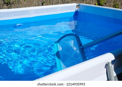 Net Of The Pool. Cleaning Of The Home Pool. Blue Water Background. Luxury In The Heat.