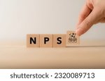 Net Promoter Score (NPS) measuring customer satisfaction and loyalty concept.Tool for measure customer loyalty and improvement products or services. Wooden cube blocks with NPS text and icon.