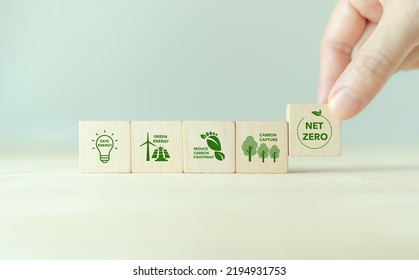 Net zero action concept. Save energy, green energy, reduce carbon footprint, carbon capture. Climate neutral long term strategy. Limit  global warming. Putting wooden cubes with green net zero icon