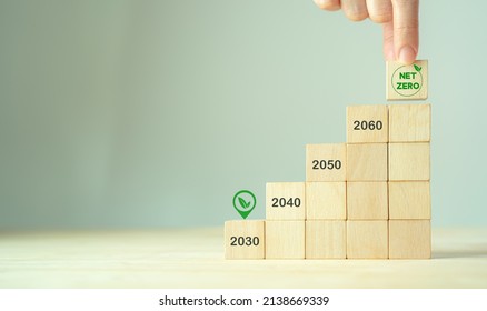 Net Zero By 2030. Carbon Neutral. Sustainalble Development. Successful Execution Of Green Business. Goal Checked In 2030. Go Green Company Culture. Hand Puts Wooden Cube With Net Zero Icon, Copy Space