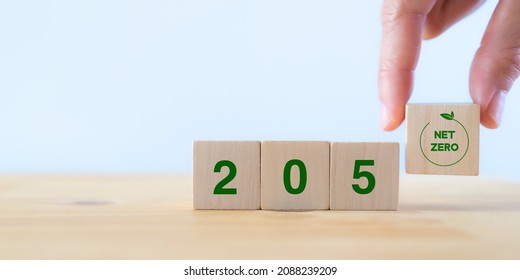 Net zero by 2050. Carbon neutral. Net zero greenhouse gas emissions target. Climate neutral long term strategy. No toxic gases. Hand puts wooden cubes with net zero icon in 2050 on white background. - Shutterstock ID 2088239209